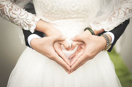 man and woman holding hands doing heart hand sign thumbnail