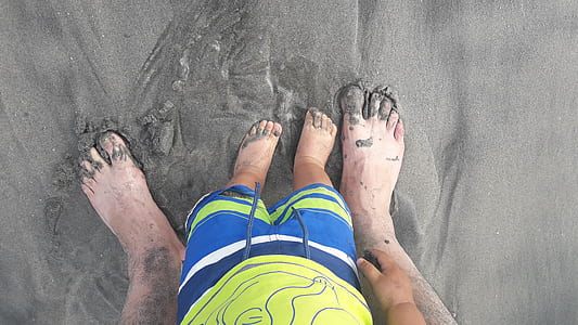 two person standing on gray sands thumbnail