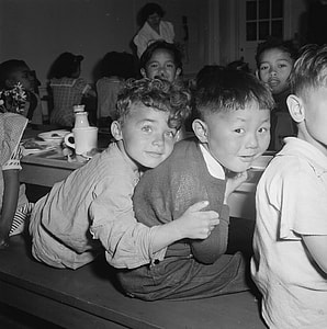 grayscale photo of children on dining set thumbnail