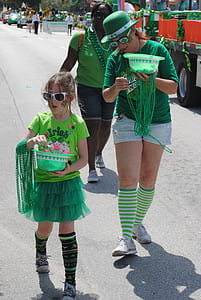 three women wearing green costumes walking on street thumbnail