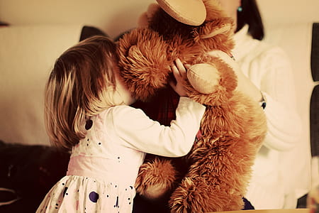 girl in white dress holding plush toy thumbnail