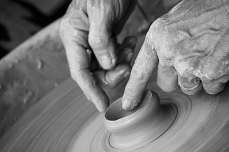 grayscale photograph of person molding vase thumbnail
