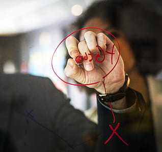 Person Wearing Black Watch Writing on Mirror Using Red Pen thumbnail