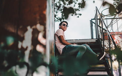 man sitting on black steel stairs thumbnail