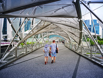 man and woman walking hallway between white metal frame thumbnail