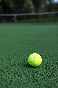 selective focus photography of green tennis ball on sod at daytime thumbnail