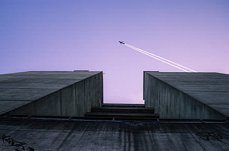 low angle view of building with plane passing by thumbnail