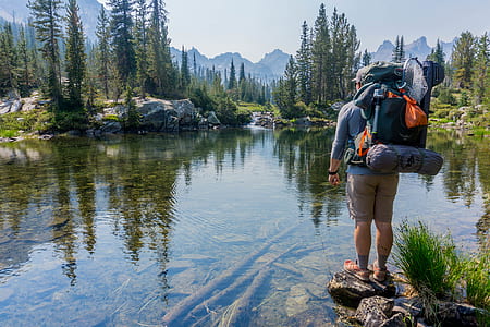 man standing on rock near body of water thumbnail