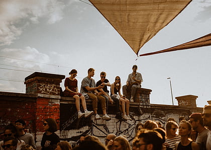group of persons sitting on fence during daytime thumbnail