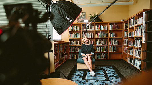 woman sitting on chair surrounded by books thumbnail