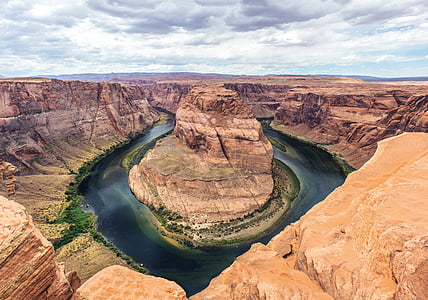 brown rock formation in the middle of bodies of water thumbnail