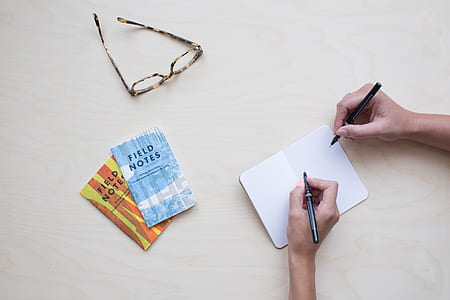 flat lay photography of two persons writing notes thumbnail