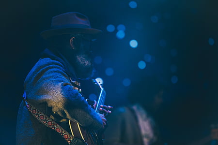 man playing guitar on black dimmed room thumbnail