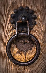 black door knocker on brown wooden surface thumbnail