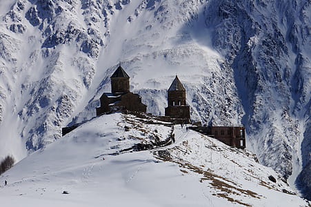brown concrete building in midst of mountain covered with snow thumbnail