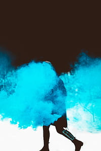 man wearing black suit covered by blue smoke thumbnail