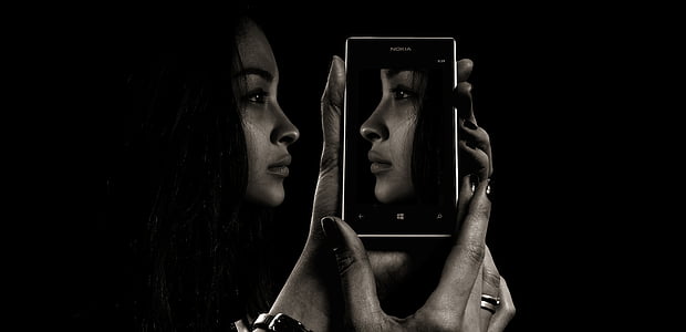 woman holding smartphone with portrait wallpaper thumbnail