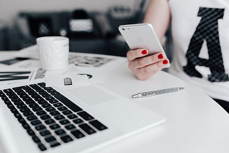 Businesswoman uses her mobile phone at her desk thumbnail