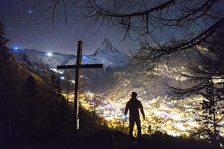 silhouette photo of man standing near cross thumbnail