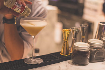 person pouring liquid in clear drinking glass thumbnail