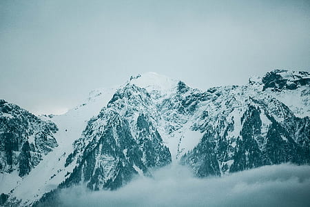 snow covered mountains under cloudy sky thumbnail