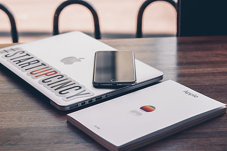 space gray iPhone 6 on MacBook Pro on brown wooden table thumbnail