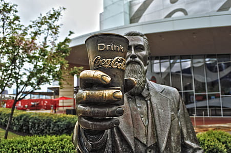 man holding coca-cola cup statue thumbnail