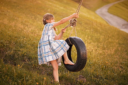 girl about to ride a swing vehicle tire at the green grass field thumbnail