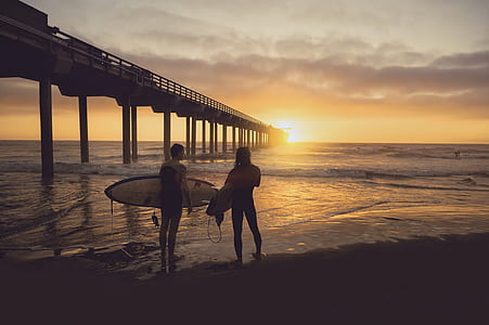 person holding surfboard standing on seashore thumbnail