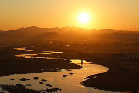 photo of mountains and body of water during golden hour thumbnail
