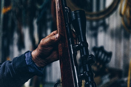 person holding brown hunting rifle thumbnail