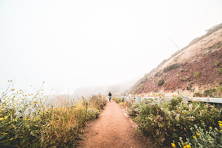 Young Woman Hiking the Mountain Trail in Foggy Weather thumbnail