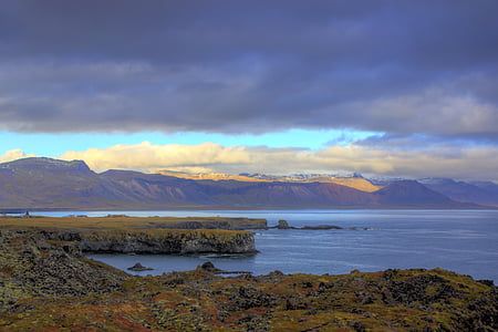 mountain surrounded by calm body of water thumbnail