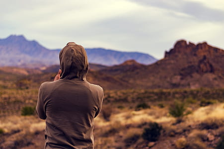 person standing in front of hill at daytime thumbnail