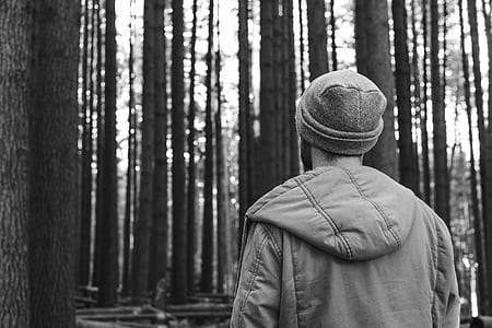 grayscale photo of man in forest at daytime thumbnail