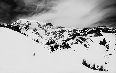 person standing on snow cap mountain under white sky at daytime thumbnail