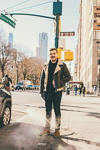 man in brown zip-up jacket standing on sidewalk thumbnail