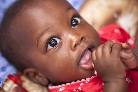 selective focus photography of baby in red shirt thumbnail