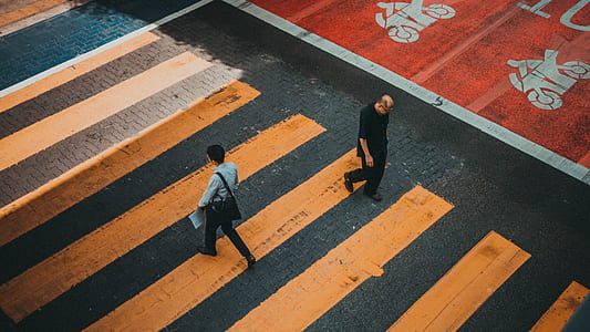 high-angle photo of two men walking on pedestrian crossing thumbnail