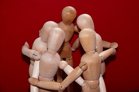 five brown wooden puppet hugging each other thumbnail