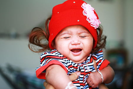 baby closing eyes wearing red hat thumbnail