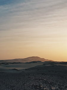 gray sand hills under white clouds at daytime thumbnail