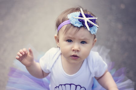 baby in white and purple tutu dress shallow focus photo thumbnail