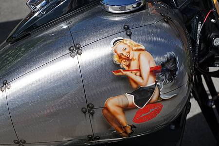 close up photography of gray motorcycle gasoline tank with woman sticker thumbnail