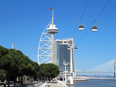 white concrete tower beside two cable cars at daytime thumbnail