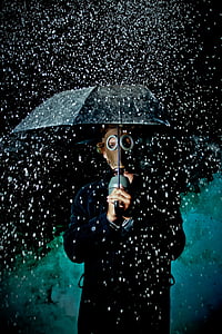 man wearing brown mask and holding umbrella thumbnail