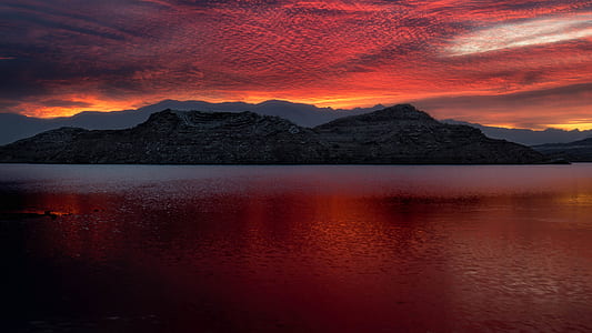 black mountain beside sea during night time thumbnail