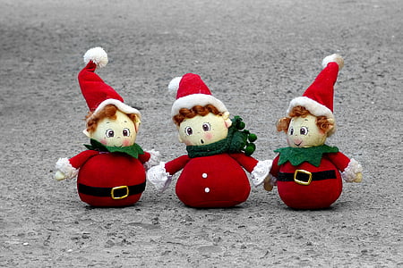 three Santa Claus dwarf dolls on concrete pavement thumbnail