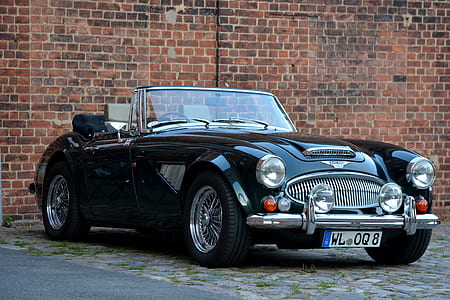 classic black coupe parked near the brick wall thumbnail