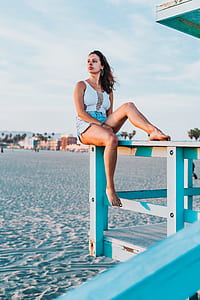 woman wearing white bikini top sitting on the end of railings photography thumbnail